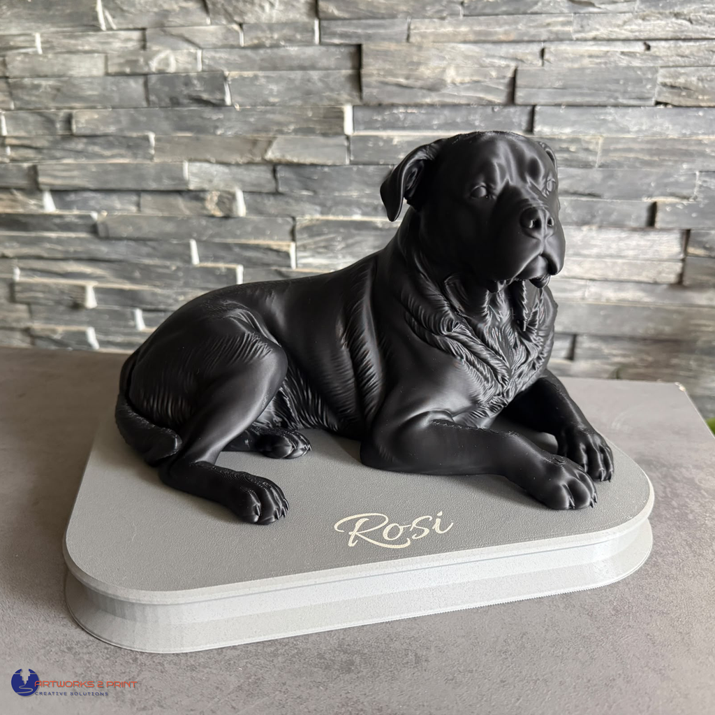 3D-gedruckte Hundefigur nach Foto, liegend auf hellem Sockel mit graviertem Namen